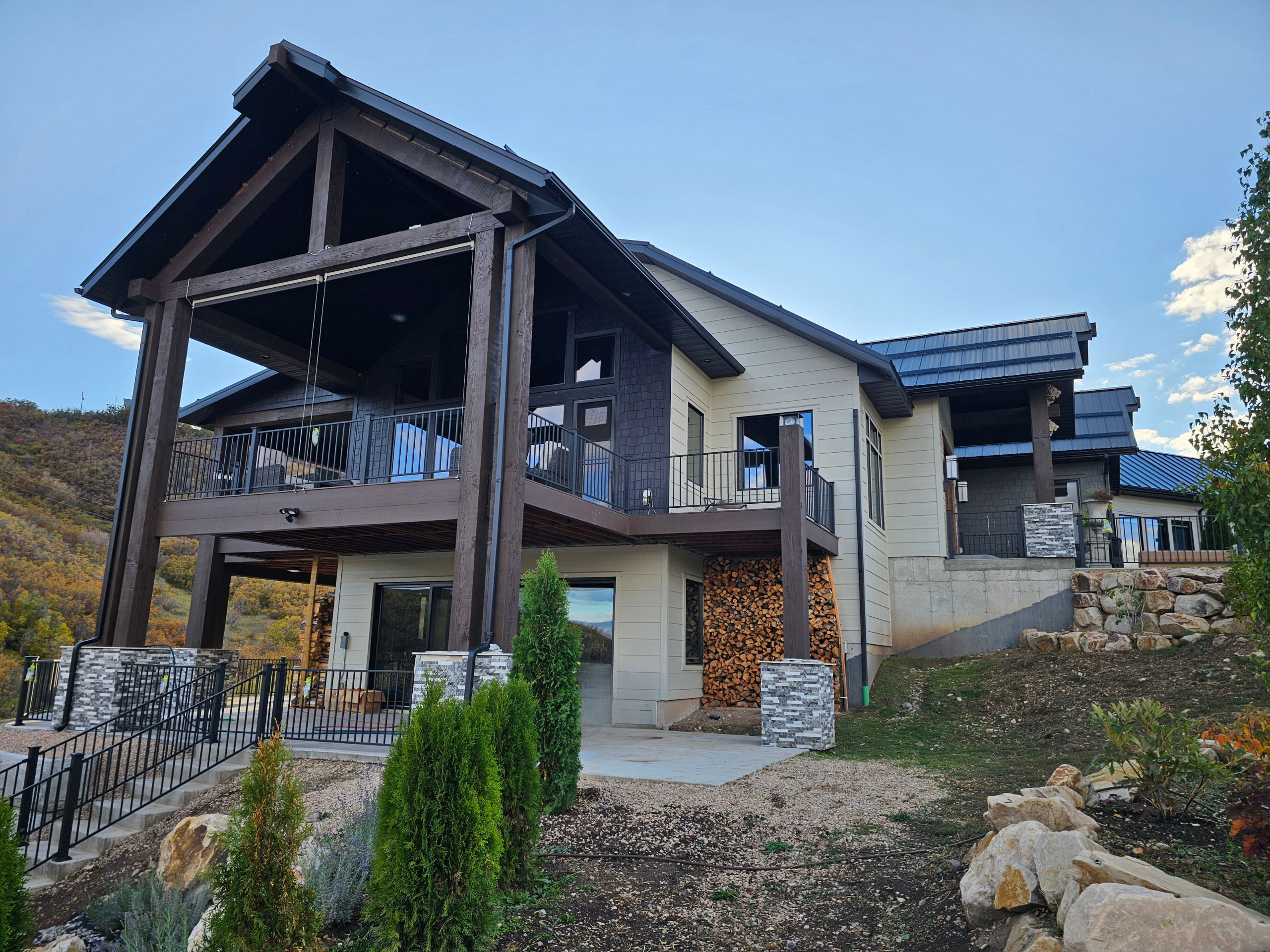 Exterior of a custom-built mountain home featuring a large covered deck, timber frame accents, and stone detailing, showcasing residential engineering services and unique home design styles.