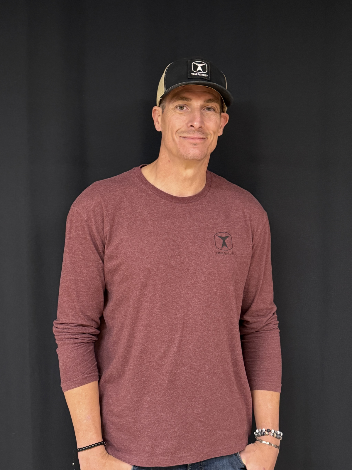 Dustin Madsen, Professional Roofer and Flooring Specialist at True Quality Construction, smiling in a branded company shirt.
