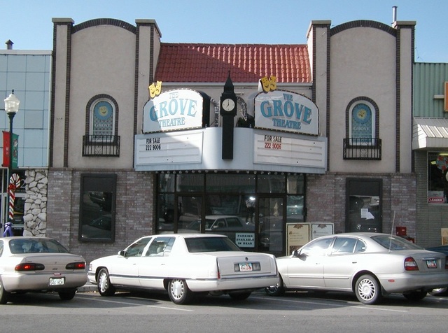 The Grove Theatre historic building in downtown Pleasant Grove, Utah with vintage cars parked outside